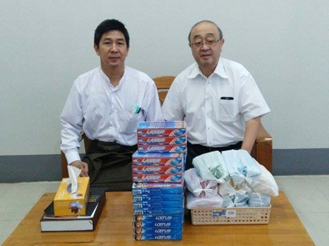 ミャンマー保健スポーツ省にて、キン・マウン先生（左）に歯ブラシ500本、歯磨き粉280本を贈呈するNPO法人日本歯科ボランティア協会の長谷川先生